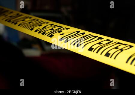 Yellow Police Crime Scene tape across a staged crime scene Stock Photo