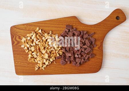 Chopped walnuts and chocolate on wooden board. Step by step recipe for Banana bread. Stock Photo
