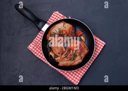 Roasted pork steak in frying pan and napkin Stock Photo