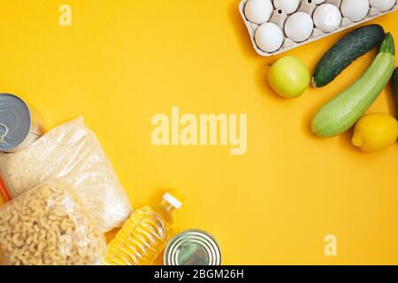 Food donations on yellow background, top view Stock Photo