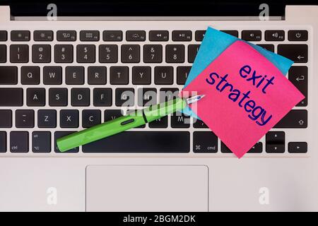 Sticky note on keyboard with text exit strategy. Conceptual. Stock Photo