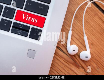 Laptop with headset and word virus on the keyboard. Stock Photo