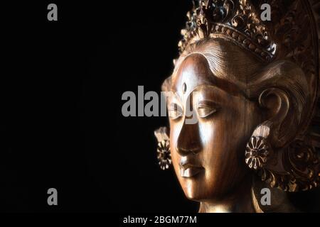 Wood carved female head. Parvati face, Hindu goddess of fertility, love, beauty, marriage, children, and devotion. Balinese handcraft. Stock Photo