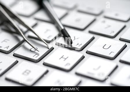 Laptop repair, screwdrivers close-up on a gray keyboard. Computer service macro Stock Photo