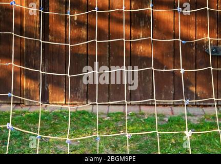 A soccer goal net against a blurred wooden background. Stock Photo