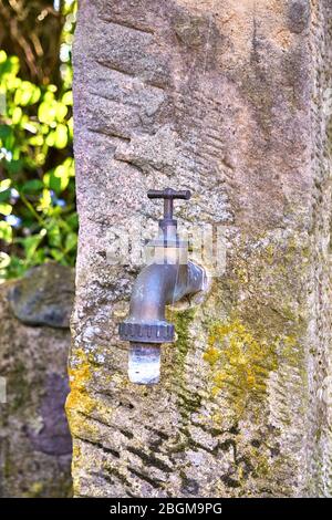 Old bronze faucet on a natural stone. Stock Photo
