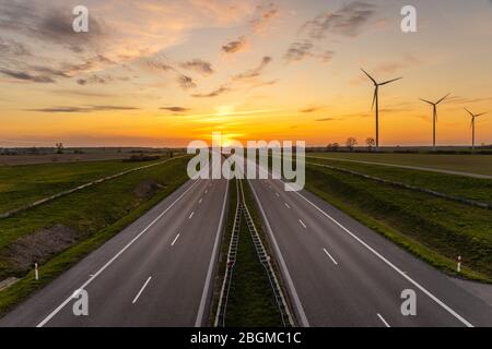setting sun over an empty highway Stock Photo