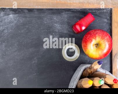 School still life with apple, colorful pencils on chalkboard Stock Photo