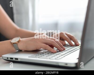 Working from home, contractor, freelance, social media, social marketing concept. Close-up woman's hands typing on laptop keyboard at home. Copy space for text or design Stock Photo