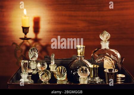 Candlelight in the bronse candlestick and various vintage perfume bottles in the old leather gripsack Stock Photo