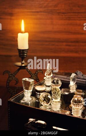 Candlelight in the bronse candlestick and various vintage perfume bottles in the old leather gripsack Stock Photo