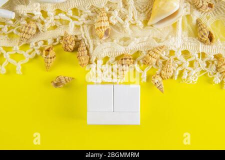 White wood cubes around the seashell isolated on a yellow background. It's lined up so you can fit in a quarter, month, and date. Front views Stock Photo