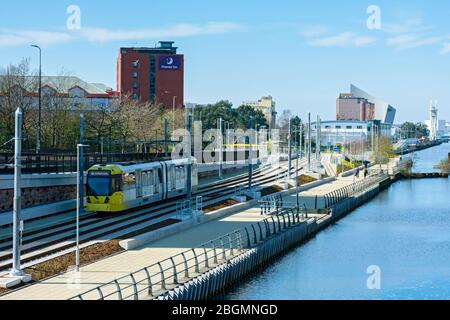 Metrolink tram alongside the Manchester Ship Canal on the opening day of the Trafford Park Line, near the Wharfside stop, Old Trafford, Manchester, UK Stock Photo