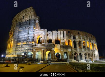 Rome, Italy. Colosseum Also Known As Flavian Amphitheatre In Evening Or Night Time. Night Traffic Light Trails Near Famous World Landmark Stock Photo