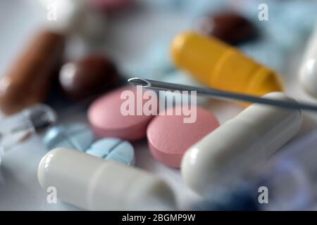 A lot of pills and capsules lie on the banknotes. Tax deduction for expenses for expensive treatment Stock Photo