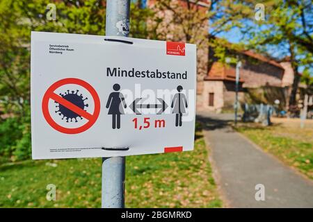 Informatory sign in the deserted city park in times of COVID-19, Nuremberg, Franconia, Bavaria, Germany Stock Photo