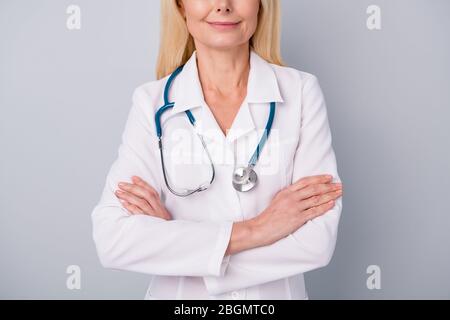 Cropped photo of experienced pensioner retired woman doc cross hands ready consult examine corona virus patient isolated over gray color background Stock Photo