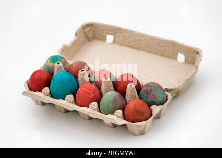 Colorful Easter eggs in cardboard egg box on white background. Raw chicken eggs in open egg box on a white background. Eggs in the package. Stock Photo