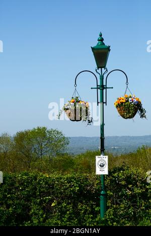 Hanging baskets on street lamp with Neighbourhood Watch sign and views across Medway valley to North Downs, Bidborough Ridge, Kent, England Stock Photo