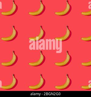 Seamless pattern with ripe yellow bananas with shadow on a red background. holiday concept. Festive background. Flat lay. Creative composition, Abstra Stock Photo