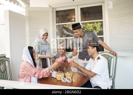 muslim friend cheering their glass together before breaking the fast on ramadan Stock Photo