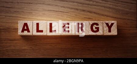 Allergy word written on wooden cubes on wooden background. Medical healthcare concept Stock Photo