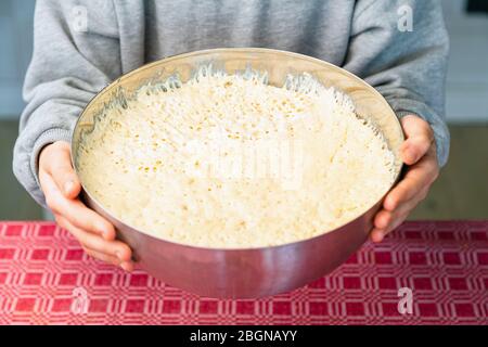 Close up of chef preparing dough for cooking bread or pizza. White round handmade dough on a kitchen table Stock Photo
