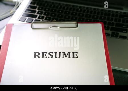Closeup of resume on top of computer laptop on table Stock Photo