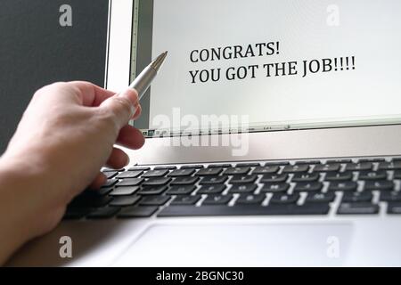 Pen pointed on the typed word, Congrat! You go the job! that appear on the computer screen. Good news concept. Stock Photo