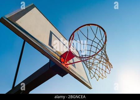 Street basketball hoop on a sunny day with blue sky in the background. Urban youth game. Concept of success, scoring points and winning Stock Photo