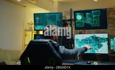 Hacker showing thumb up sign while programming a virus to attack the government security. Stock Photo