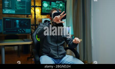 Cyber criminal using virtual reality goggles to steal online identity. Stock Photo