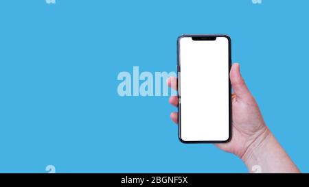 Modern smartphone with blank screen in female hand isolated on blue background mock up. Stock Photo