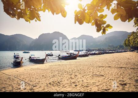 Long tail boats on tropical beach at beautiful sunset on Koh Phi Phi island, Thailand Stock Photo