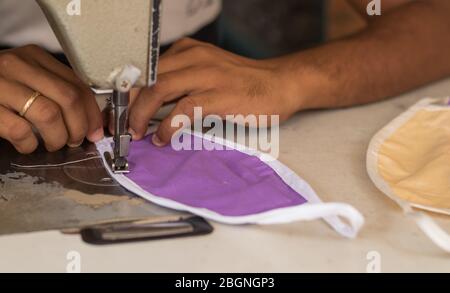Home made diy protective mask against virus during mask shortage - Using sewing machine to sew the face medical mask during coronavirus or covid-19 Stock Photo