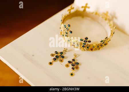 Golden crown with wedding crosses and gold earrings Stock Photo