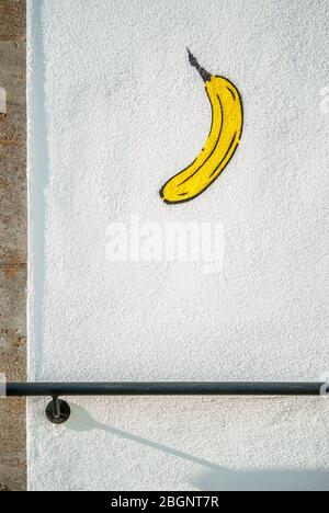 Banana painted on white house wall Graffiti with handrail Stock Photo