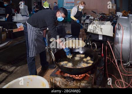 Volunteers prepare free hot meals for distibution during the coronavirus crisis in London, UK on April 22, 2020. 'Food For All' are a London based charity offering a free hot meal service to people in need in inner London throughout the Covid-19 pandemic. Food is donated by New Covent Garden Market and wholesalers. They deliver meals to local distribution hubs, food banks and mutual aid groups. Today 3,000 meals are being prepared with capacity to deliver 20,000 per day. (Photo by Claire Doherty/Sipa USA) Stock Photo