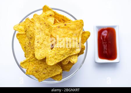 Triangular corn chips, mexican nachos with sauces tomato ketchup, close-up. Stock Photo