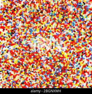 Multicolored colorful glass beading abstract background close up on white handmade crafts backdrop Stock Photo