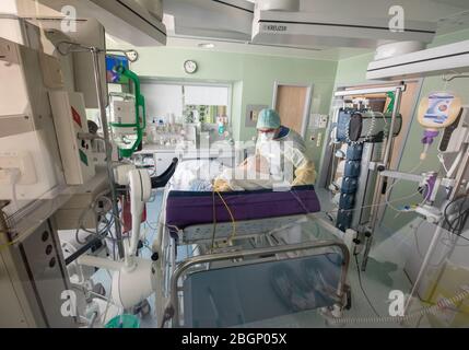 Gauting, Germany. 22nd Apr, 2020. Chief physician Lorenz Nowak (r) examines a corona patient who tested positive in protective clothing in an isolated intensive care bed room in the Asklepios Klinik. Credit: Peter Kneffel/dpa/Alamy Live News Stock Photo