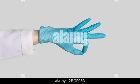 Female hand in rubber glove shows ok sign Stock Photo