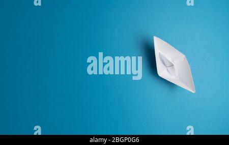 top view of white paper boat on blue background Stock Photo