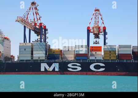 Container ship being positioned by a tug Stock Photo