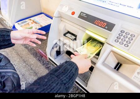 A woman is inserting her Japanese banknote to a machine to refill her Suica card for travelling by Tokyo subway sustem. Tokyo, Japan February 8,2020 Stock Photo