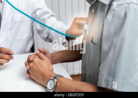 Doctor Checking Patient With Stethoscope. Doctor listening to patient chest with stethoscope in his office at the hospital. Stock Photo