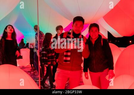 An Asian couple selfies with projector and reflecting light effect art at teamLab Borderless Tokyo Odaiba, Tokyo/Japan February 8,2020 Stock Photo