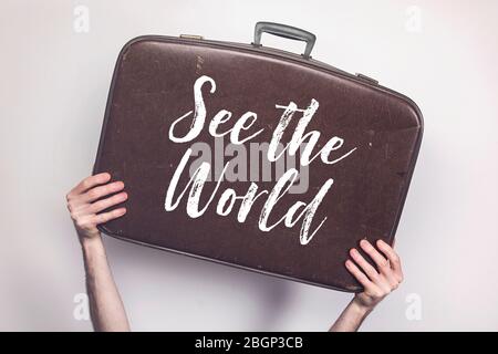 See the world message on a vintage travel suitcase Stock Photo