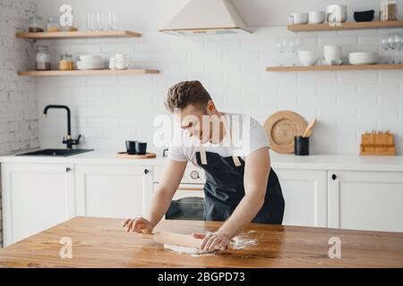 Chef hands rolling pizza dough on light kitchen background Stock Photo