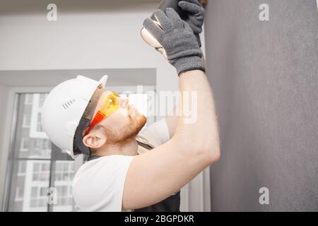 Electrician worker man assembling electric lamps in new apartment Stock Photo